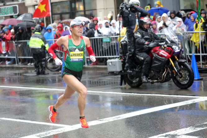 Nhà vô địch Marathon Boston 2018 - Yuki Kawauchi trên đường chạy, và bên đường là lá cờ VN - chỉ dấu cho biết người Việt chính thức dự giải. Ảnh trên báo Boston Herald