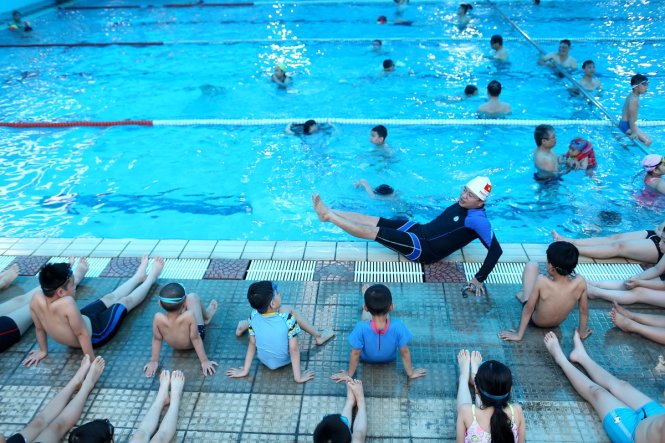 Anh Nguyễn Văn Thủy hướng dẫn bài tập trên cạn cho các em nhỏ tại bể bơi Học viện Chính trị quốc gia. Ảnh: Nam Khánh