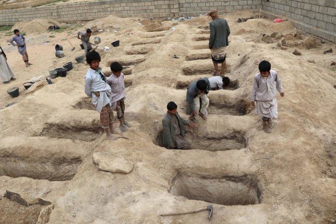 Trẻ em Yemen giúp đào hố chôn những người chết vì chiến tranh và thảm họa nhân đạo. Ảnh: Reuters