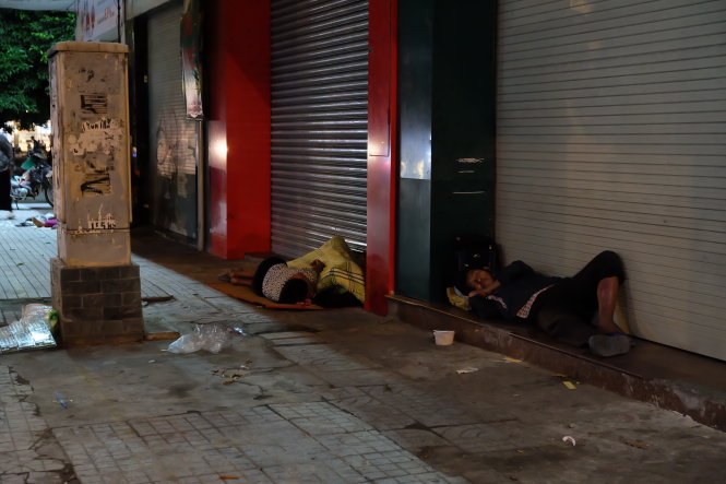 Khi hàng quán đóng cửa cũng là lúc nhiều người chọn cho mình một chỗ ngủ dưới mái hiên (ảnh chụp tại đường Phan Đăng Lưu, quận Phú Nhuận)  Ảnh: CÔNG TRIỆU