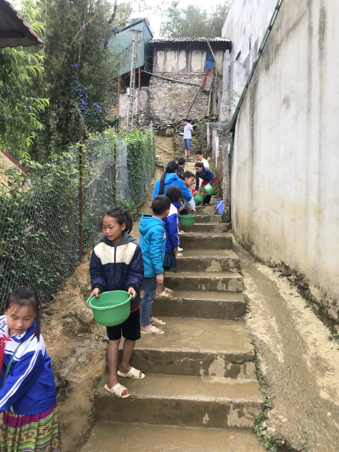 Các học sinh ở Trường dân tộc nội trú tại Sa Pa đang chuyền nước sạch do chính quyền phân phát với số lượng hết sức khiêm tốn. Ảnh: Bá Hiếu