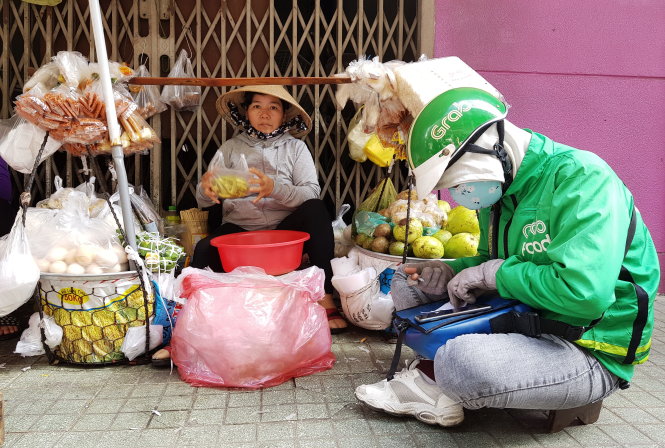 Từ chỗ bán hàng rong với đôi quang gánh (ảnh trái), bà Nguyễn Thị Cảnh (quê Bình Định) 2 năm nay phải tăng cường người và thuê thêm mặt bằng để phục vụ người mua qua mạng (ảnh phải). Ảnh: NGỌC HIỂN