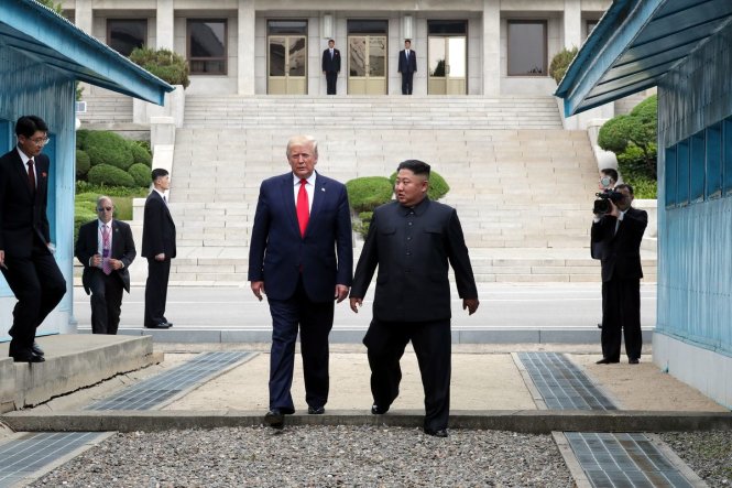 Ông Trump (trái) và ông Kim cùng nhau bước qua giới tuyến khu phi quân sự giữa hai miền Triều Tiên. Ảnh: AFP