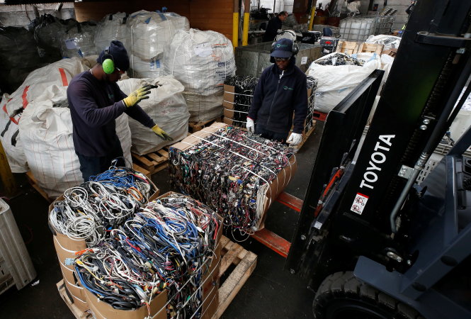 Công nhân di chuyển các kiện dây cáp phế liệu tại một nhà máy xử lý rác điện tử và giấy ở Santiago, Chile. Ảnh: Reuters