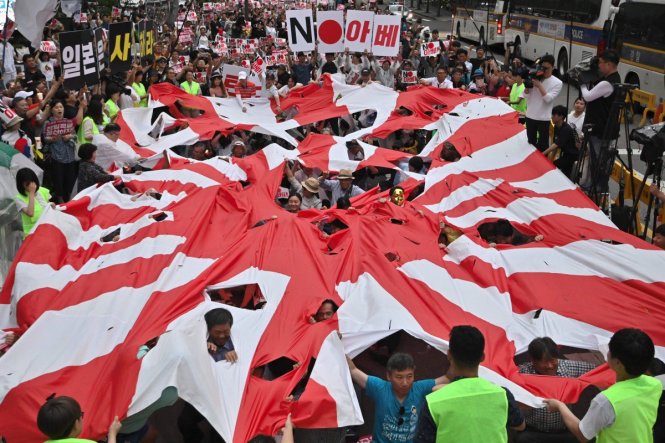 Người Hàn Quốc biểu tình với một lá cờ đế quốc Nhật Bản rách. Ảnh: SCMP