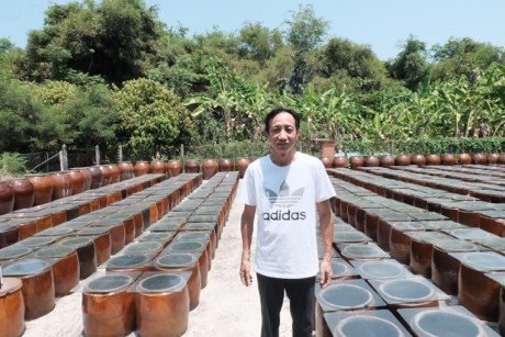 Anh Lê Kim Sơn ở sân ủ tương trước ngôi nhà tổ tiên để lại. Ảnh: Pha Lê