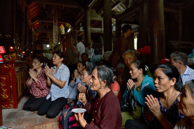 Dùng hai đồng xu để cầu xin sự linh ứng và dự báo về may mắn trong một nghi lễ diễn ra dịp Vu Lan tại chùa Phổ Minh (Nam Định). Ảnh: Nicolas Cornet