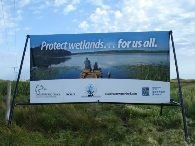 Biển truyền thông kêu gọi người dân bảo vệ nguồn nước “vì tất cả chúng ta” của Hiệp hội quản lý đầu nguồn Assiniboine được đặt tại nhiều nơi ở Canada. Ảnh: Assiniboine Watershed