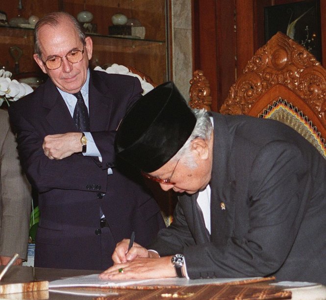 Tấm hình nổi tiếng: tổng giám đốc IMF Michel Camdessus khoanh tay chứng kiến tổng thống Indonesia Suharto ký văn kiện xin cứu trợ.-Ảnh: Bloomberg
