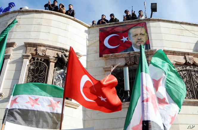 Lực lượng nổi dậy Quân đội giải phóng Syria thượng cờ Thổ Nhĩ Kỳ và treo hình ông Erdogan ở thị trấn miền bắc Syria Azez. Ảnh: AP