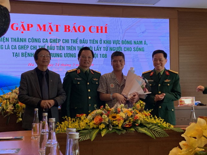 Anh Phạm Văn Vương nhận hoa chúc mừng của các bác sĩ (bên phải là GS.TSKH Nguyễn Thế Hoàng - phẫu thuật viên chính của ca ghép tay cho anh). Ảnh: L.Anh