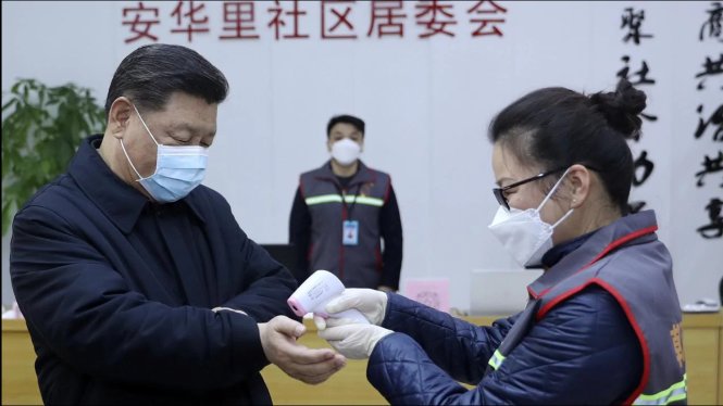 Nhân viên y tế kiểm tra nhiệt độ ở cổ tay cho Chủ tịch Trung Quốc Tập Cận Bình khi ông tới thăm một cơ sở y tế ở Bắc Kinh. Ảnh: AP