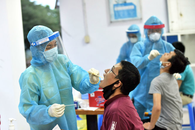 Công nhân lưu trú thuộc Khu chế xuất Tân Thuận được nhân viên y tế lấy dịch ở họng và mũi (ảnh chụp tháng 4-2020). Ảnh: DUYÊN PHAN