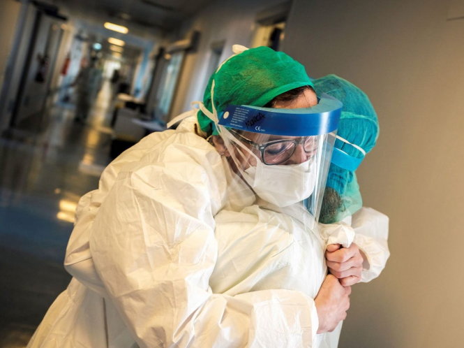 Hai y tá tại Bệnh viện Cremona ở Lombardy ôm động viên nhau trong khi chiến đấu chống dịch COVID-19 tại Ý. Ảnh: AFP