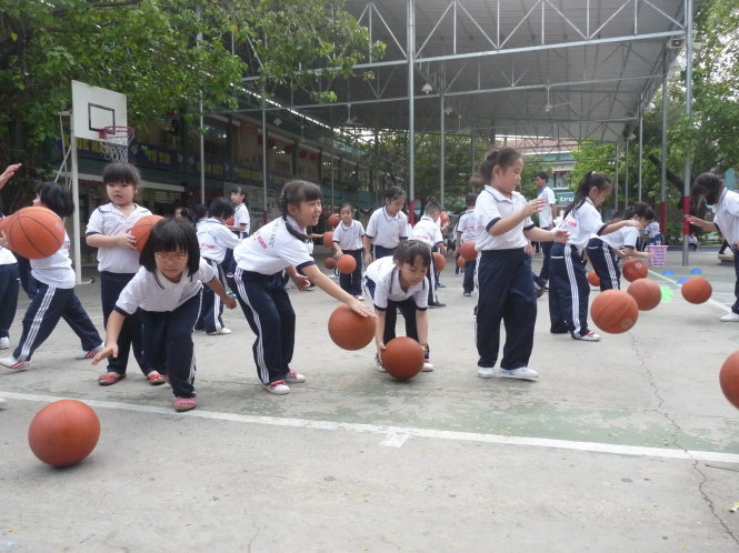 Học sinh lớp 1 Trường tiểu học Lương Thế Vinh học chơi bóng rổ trong tiết thể dục. Ảnh tư liệu 2015: Xuân Bình