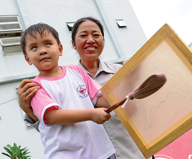 Một em nhỏ của Trung tâm khiếm thị Nhật Hồng cổ vũ cho trận đấu - Ảnh: Quang Định