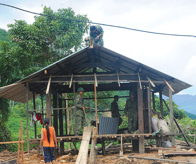 Bộ đội giúp dân vùng thủy điện Đắk Đrinh (Kon Tum) làm nhà tái định cư sau thủy điện - Ảnh: Thái Bá Dũng