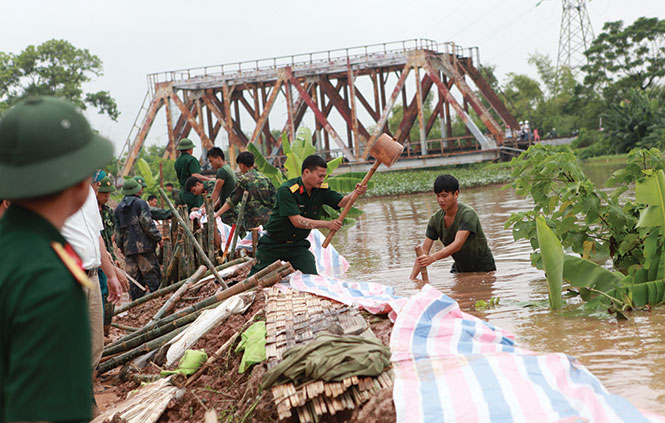 Chiến sĩ Bộ tư lệnh thủ đô gia cố đoạn đê sông Nhuệ trên địa bàn phường Tây Mỗ (quận Nam Từ Liêm, Hà Nội) để chống nước tràn vào nội thành do bão số 6 gây ra - Ảnh: Tuấn Phùng