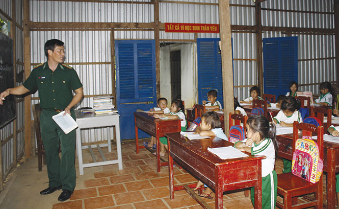 Thầy giáo biên phòng Trần Bình Phục trong lớp học cho các bé từ lớp 1 đến lớp 5 trên đảo Hòn Chuối (huyện Trần Văn Thời, Cà Mau) - Ảnh: Cầm Phan