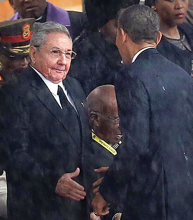 Ông Barack Obama chủ động tiến tới bắt tay ông Raúl Castro khi đi tới bục diễn thuyết tại lễ tang Nelson Mandela ngày 10-12-2013 - Ảnh: ap