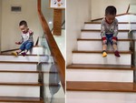 Bé trai lấy bậc thang làm cầu tuột
