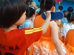 Bé gái cầm dép bắt chước phụ huynh quay video