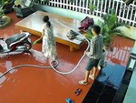 Chồng cười khoái chí khi rửa sân xịt nước ướt người vợ