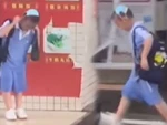 Cậu bé lấy khẩu trang che đầu vì khi không có dù