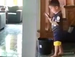 Bé trai mãi xem điện thoại ngồi gọn vào thùng nước