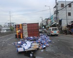 Xe container chở bia lật ngang, dân giúp tài xế gom bia