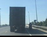 Xe máy chở 2 người núp bóng xe container để tránh nắng bất chấp nguy hiểm