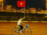 Nam sinh Sài Gòn ung dung đạp xe với lá cờ người lạ tặng
