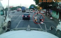 2 cô gái dừng xe máy giữa đường chờ đèn đỏ để rẽ trái