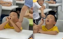 Bé trai ngồi ngủ gật trong lớp học