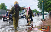 Đường Phạm Văn Đồng ngập, kẹt xe sau mưa lớn, CSGT phải moi rác cho nước chảy