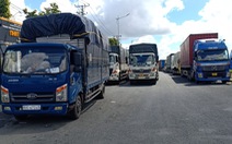 Hàng chục xe chở hàng thiết yếu bị kẹt tại chốt do quy định phải 'xuống hàng sang xe'