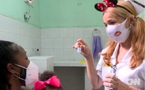 Y bác sĩ Cuba đeo băng đô chuột Mickey khi chích ngừa cho trẻ