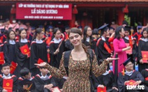 Du khách nước ngoài thích thú chụp ảnh tốt nghiệp cùng học sinh Việt Nam