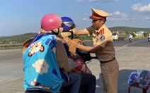 Cảnh sát giao thông phát quà và đổi mũ bảo hiểm miễn phí cho người về quê ăn Tết