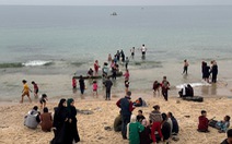 Trẻ em chơi đùa trên bãi biển Gaza khi tiếng súng lặng im