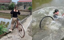 Cô gái tập đi xe đạp ngã xuống ao