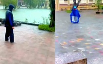 Hai người đàn ông mặc áo mưa 'chăn' cá Koi trên đường ngập