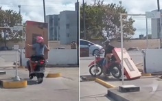 Cô gái ngồi xe máy ôm tivi ngã ngửa bởi thanh giới hạn chiều cao