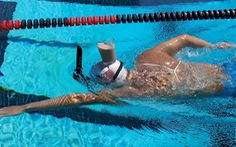 Vận động viên Olympic giữ thăng bằng cốc sữa trên đầu khi bơi