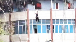 Video: Người đàn ông treo mình ở cửa sổ, rồi 'buông tay' để thoát khỏi tòa nhà đang cháy