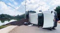 Video: Xe container nổ lốp, lật nhào trước trạm thu phí, hàng chục tấn vỏ hạt điều tràn xuống ao