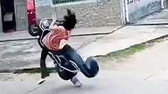 Vướng dây điện, cô gái và xe máy lộn ngược về phía sau