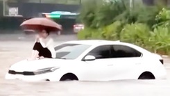 Đường Hà Nội ngập sau mưa, lên nắp ca pô ngồi chờ giải cứu