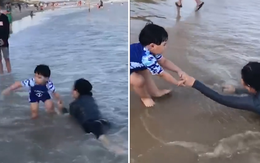 Bé trai sợ biển nhưng vẫn chạy ra cứu mẹ