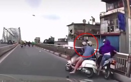 Hai cô gái ngã xe máy vì mải nhìn thanh niên nhặt mũ bảo hiểm